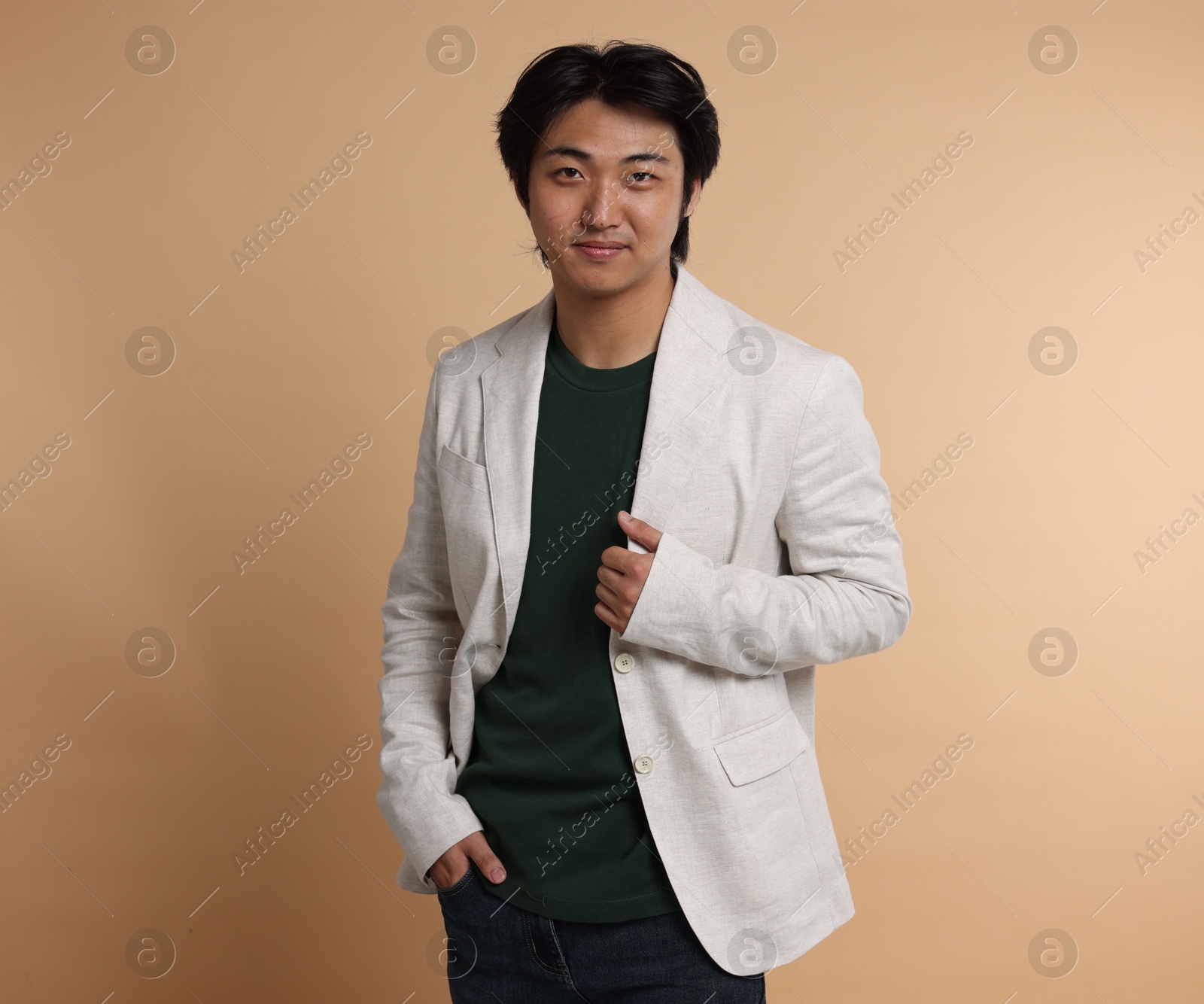 Portrait of handsome Asian businessman in suit on beige background Photo of Portrait of handsome Asian businessman in suit on beige background