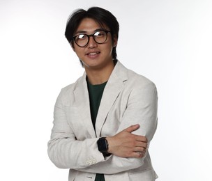 Photo of Portrait of smiling Asian man in glasses with crossed arms on white background