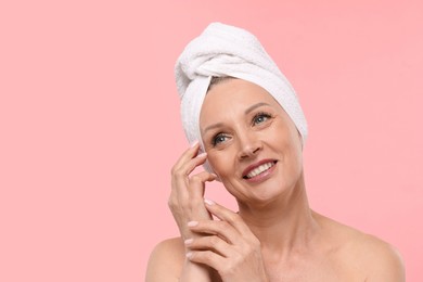 Photo of Beautiful woman with towel wrapped on her head against light pink background. Space for text