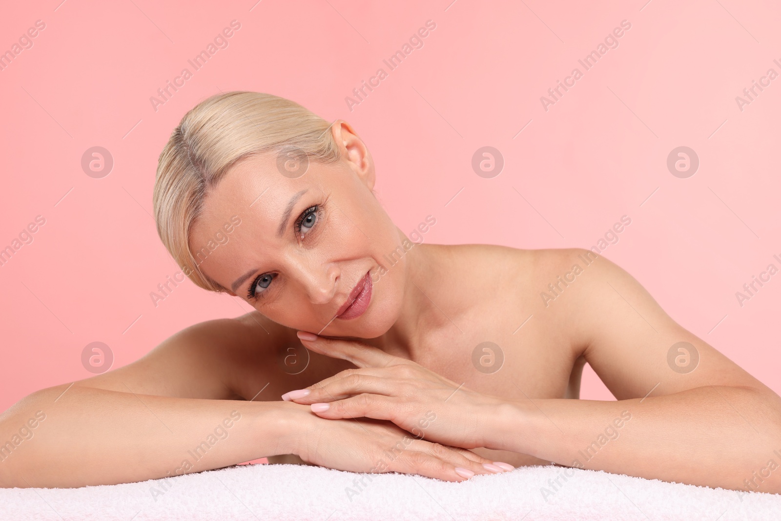Photo of Beautiful woman with towel on light pink background