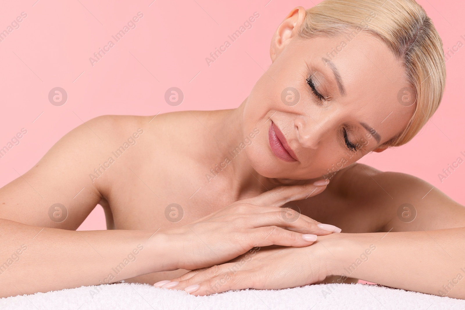 Beautiful woman with towel on light pink background Photo of Beautiful woman with towel on light pink background