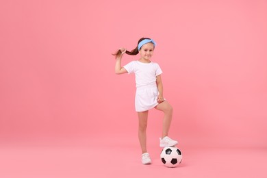 Photo of Little girl with soccer ball on pink background