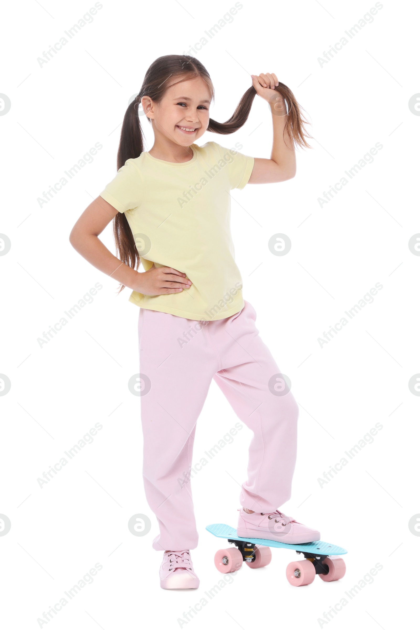 Little girl with penny board on white background Photo of Little girl with penny board on white background