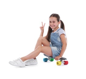 Photo of Little girl with penny board showing V sign on white background