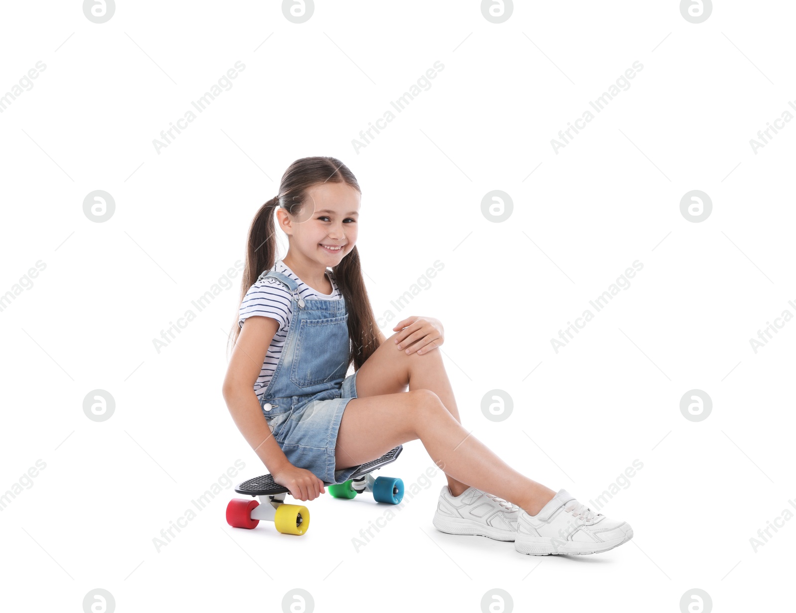 Little girl with penny board on white background Photo of Little girl with penny board on white background