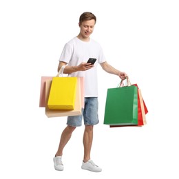 Photo of Cheerful man with smartphone and shopping bags on white background