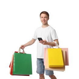 Photo of Cheerful man with smartphone and shopping bags on white background