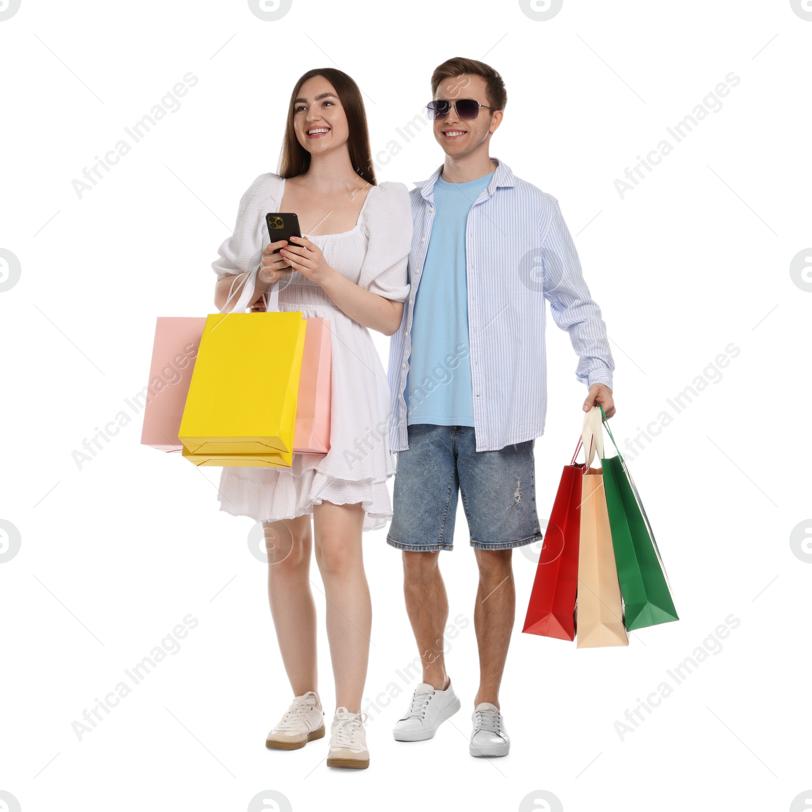 Happy couple with smartphone and shopping bags on white background Photo of Happy couple with smartphone and shopping bags on white background