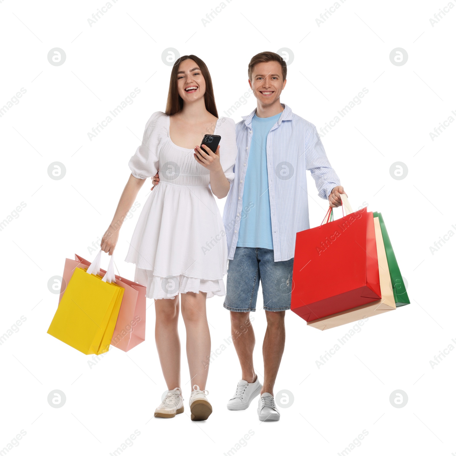 Happy couple with smartphone and shopping bags on white background Photo of Happy couple with smartphone and shopping bags on white background