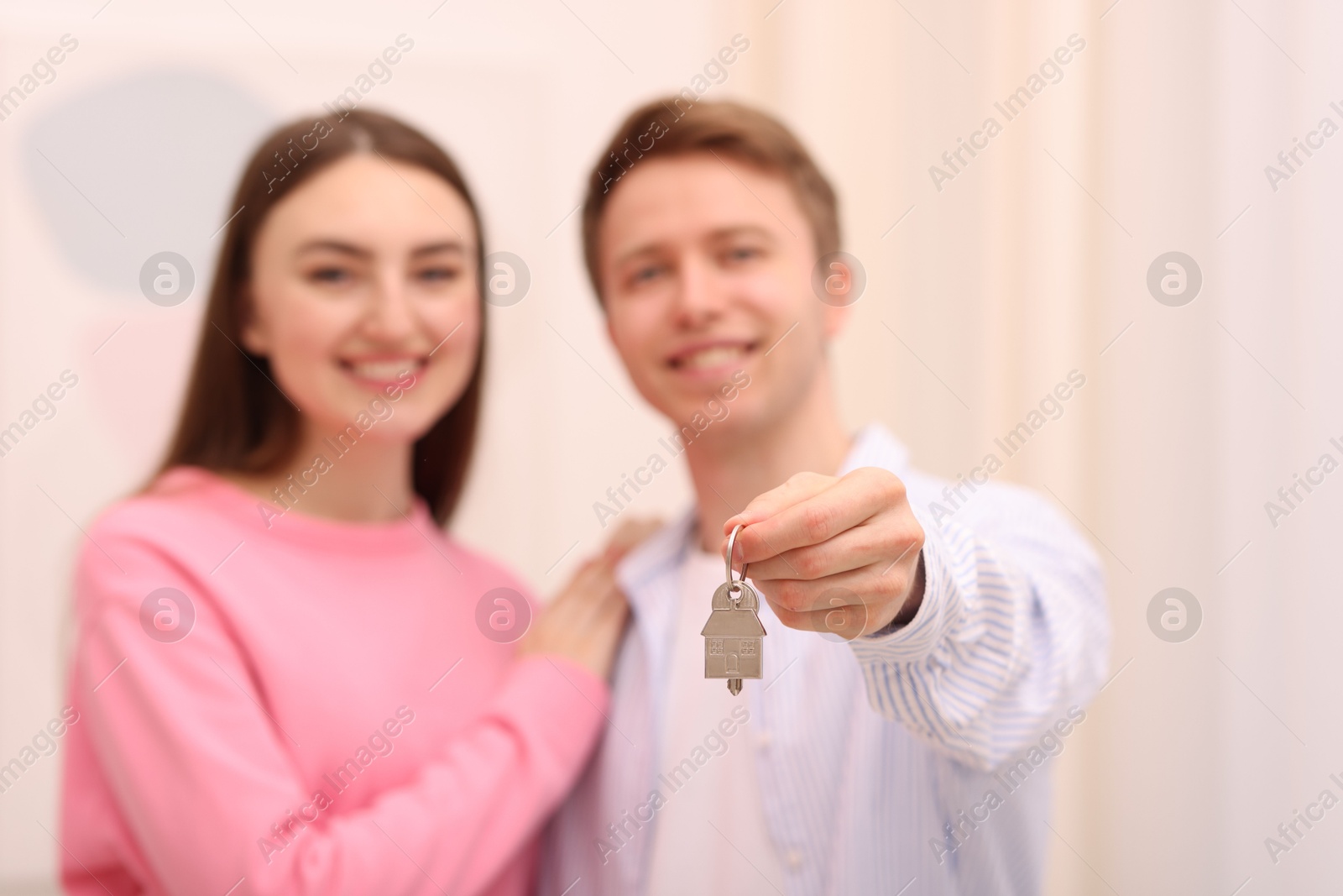 Happy couple with key of their new apartment indoors, selective focus Photo of Happy couple with key of their new apartment indoors, selective focus