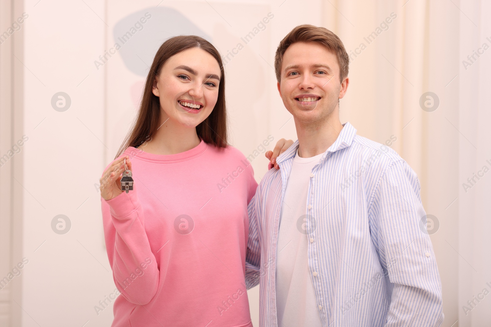 Happy couple with key of their new apartment indoors Photo of Happy couple with key of their new apartment indoors