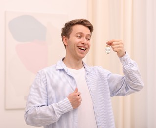 Photo of Happy man with house keys at home