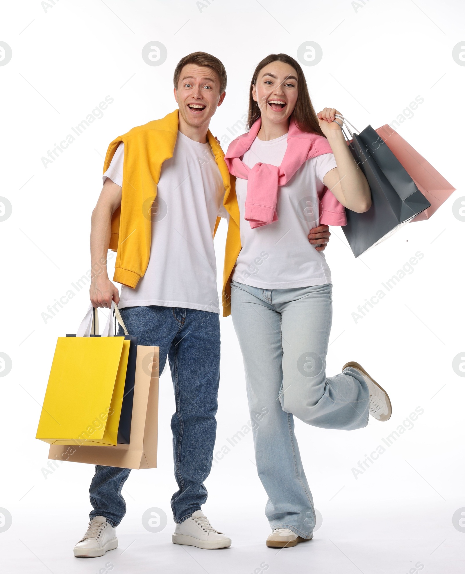 Happy couple with shopping bags on white background Photo of Happy couple with shopping bags on white background