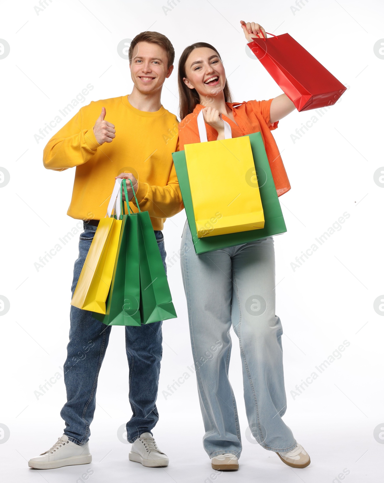 Happy woman and man with shopping bags showing thumbs up on white background Photo of Happy woman and man with shopping bags showing thumbs up on white background