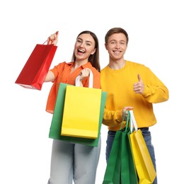 Photo of Happy woman and man with shopping bags showing thumbs up on white background