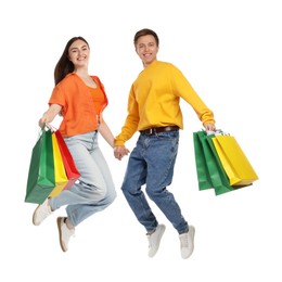 Photo of Happy couple with shopping bags jumping on white background