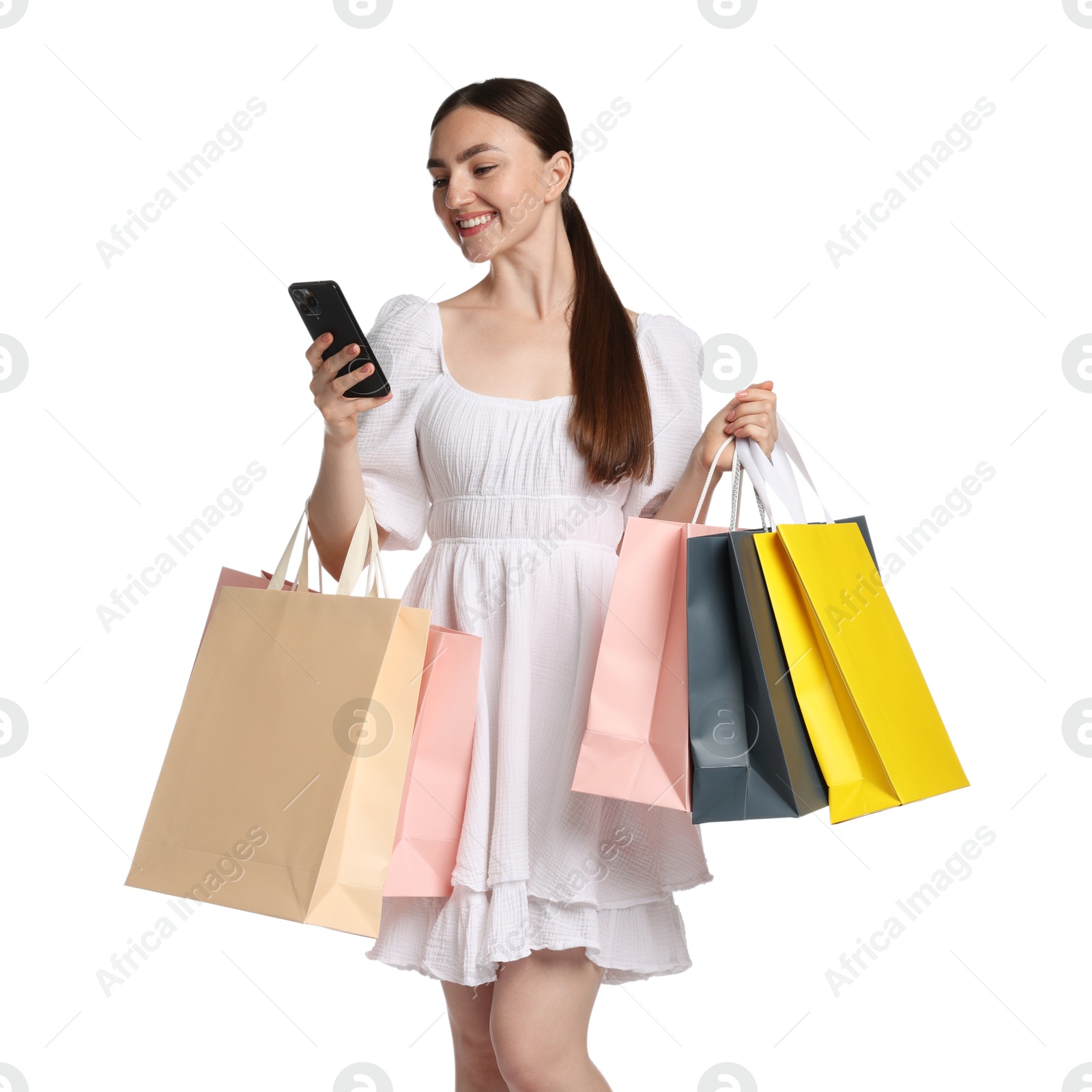 Positive woman with smartphone and shopping bags on white background Photo of Positive woman with smartphone and shopping bags on white background