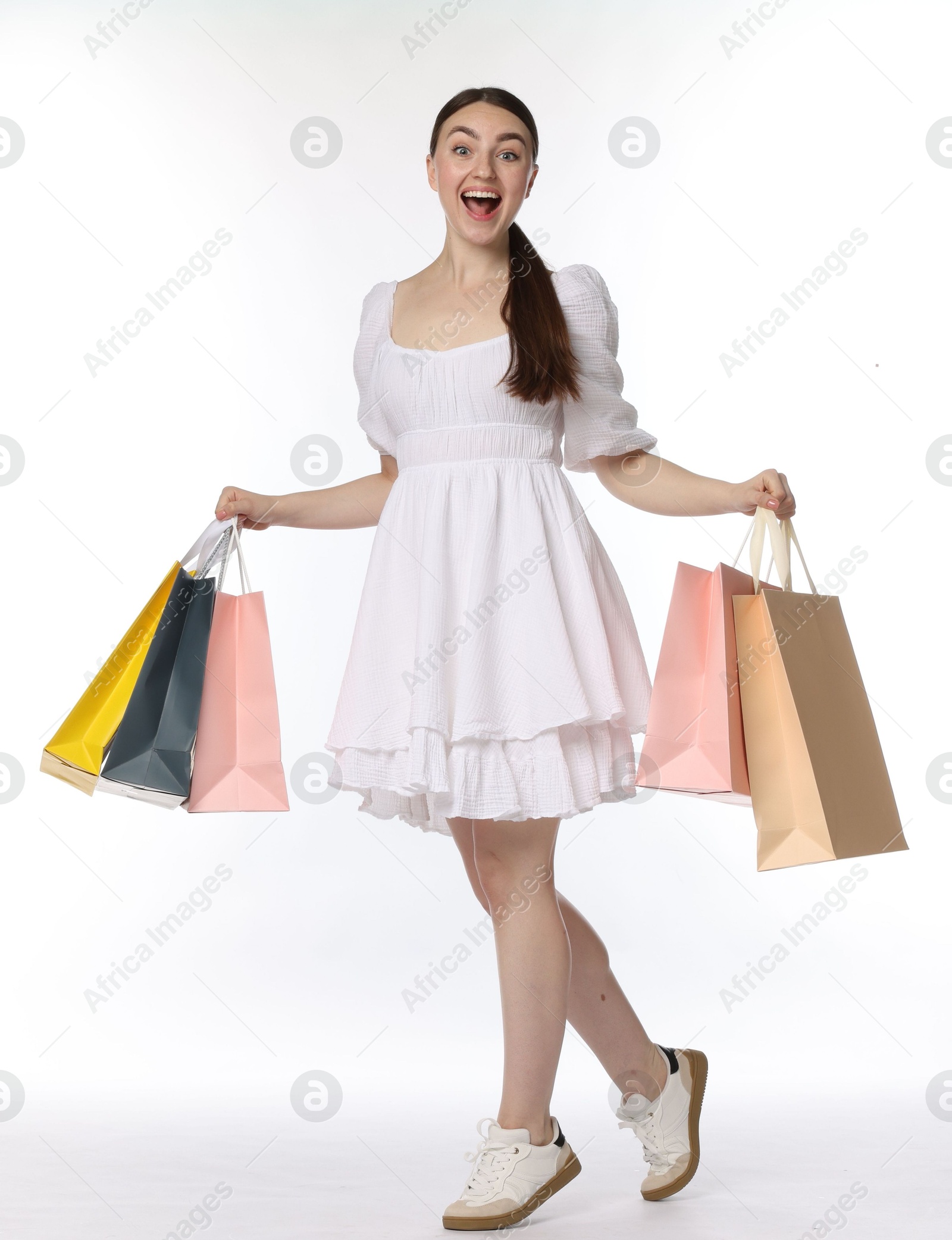 Excited woman with shopping bags on white background Photo of Excited woman with shopping bags on white background