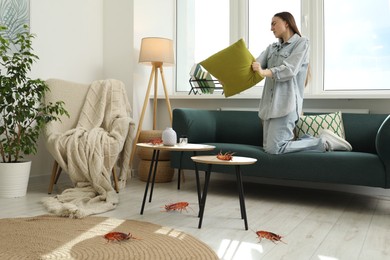 Image of Emotional young woman with pillow frightened by cockroaches at home