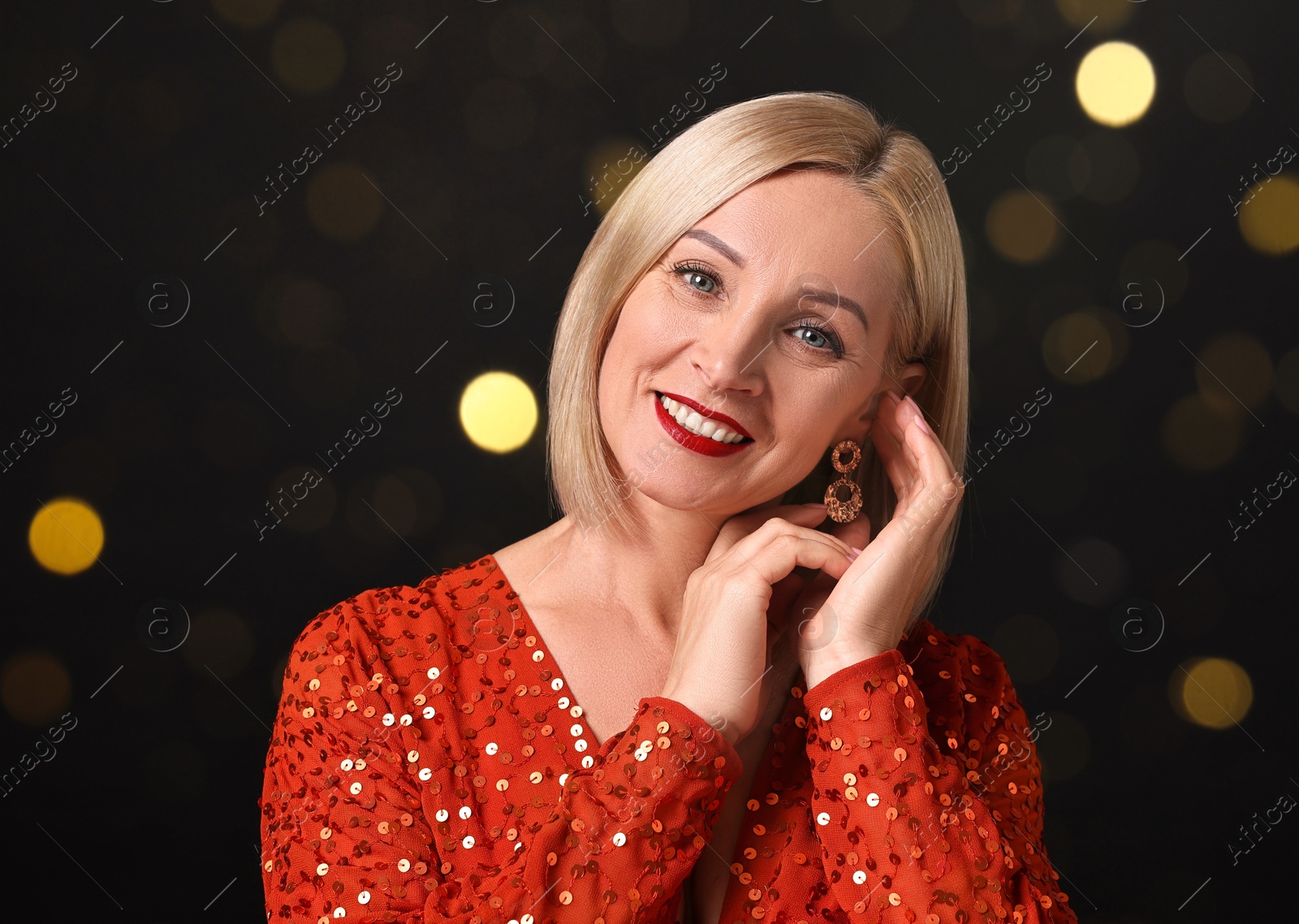 Smiling woman with perfect makeup on black background, bokeh effect Image of Smiling woman with perfect makeup on black background, bokeh effect