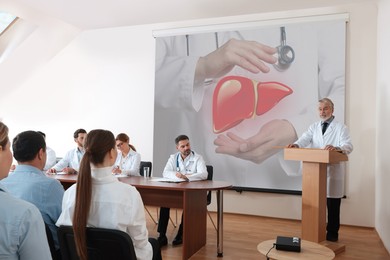 Image of Healthcare professional giving lecture about liver in conference room using video projector. Illustration on projection screen