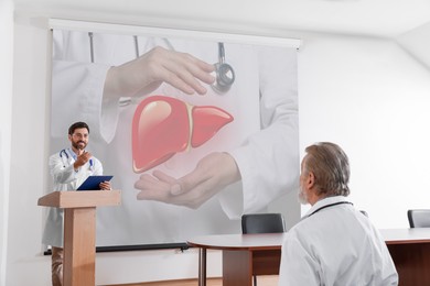 Image of Healthcare professional giving lecture about liver in conference room using video projector. Illustration on projection screen