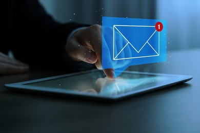 Image of Email marketing, new message notification. Man using tablet computer at table indoors, closeup
