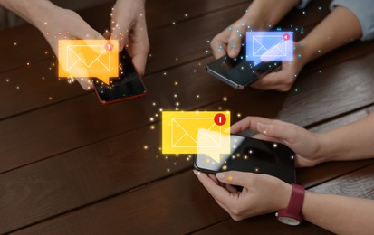 Image of Email marketing, new message notification. People using mobile phones at wooden table, closeup