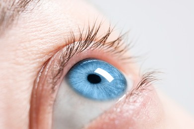 Image of Closeup view of woman with blue eyes on light background