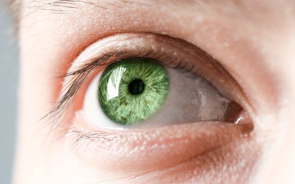 Image of Closeup view of man with green eyes on grey background