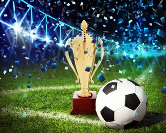 Image of Football championship. Shiny golden trophy cup and soccer ball under falling confetti on stadium