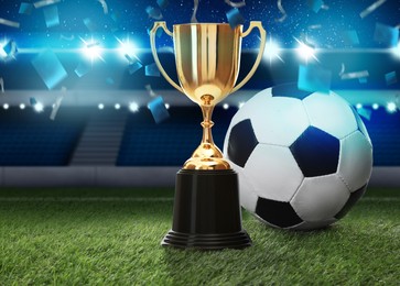 Image of Football championship. Shiny golden trophy cup and soccer ball under falling confetti on stadium
