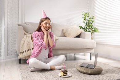 Photo of Birthday celebration. Happy woman with piece of cake having video call via laptop at home
