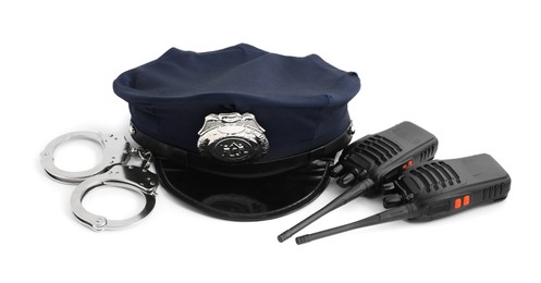 Photo of Police cap, walkie talkies and handcuffs on white background