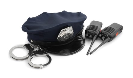 Photo of Police cap, walkie talkies and handcuffs on white background