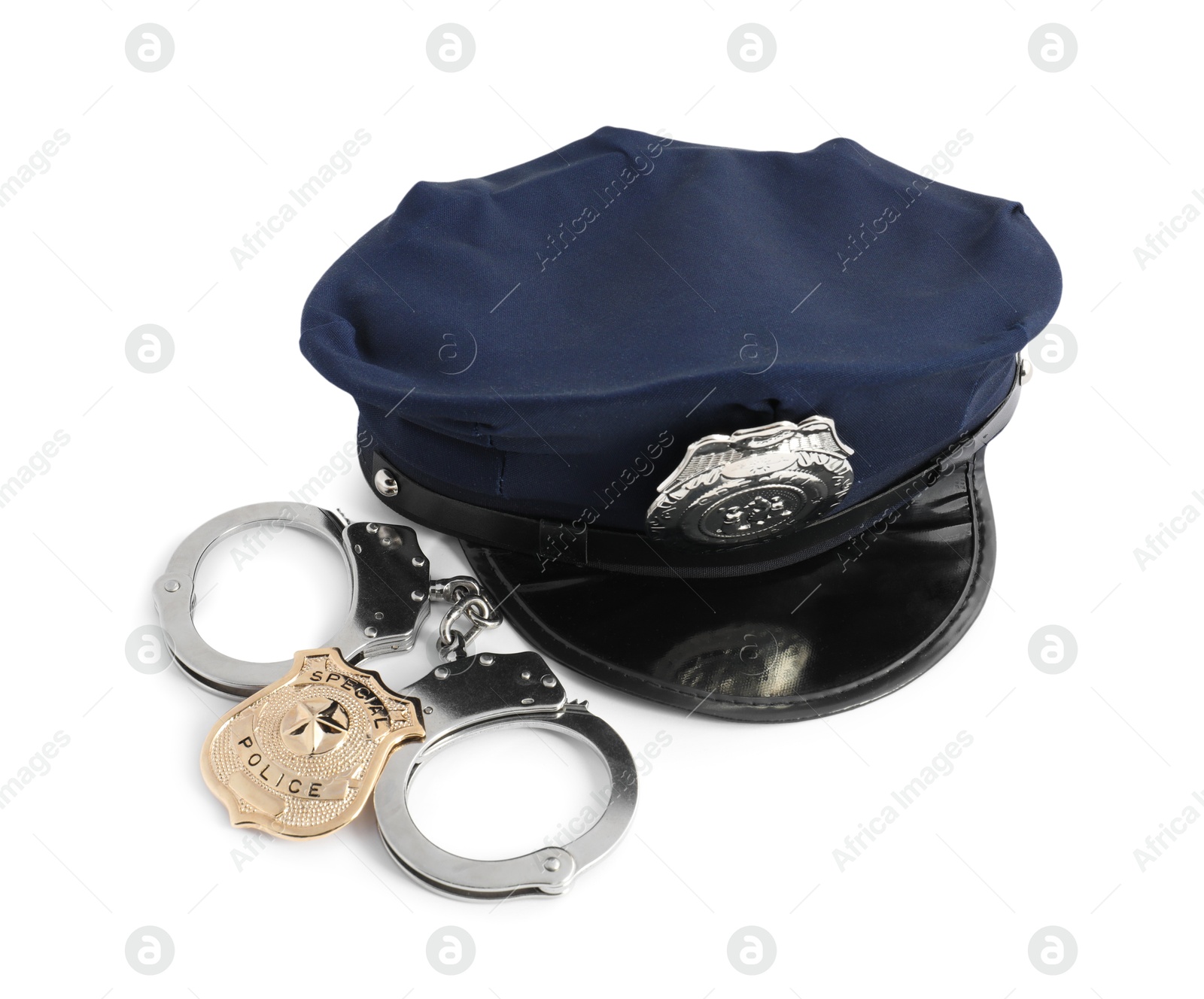 Police cap, badge and handcuffs on white background Photo of Police cap, badge and handcuffs on white background