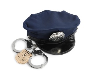 Photo of Police cap, badge and handcuffs on white background