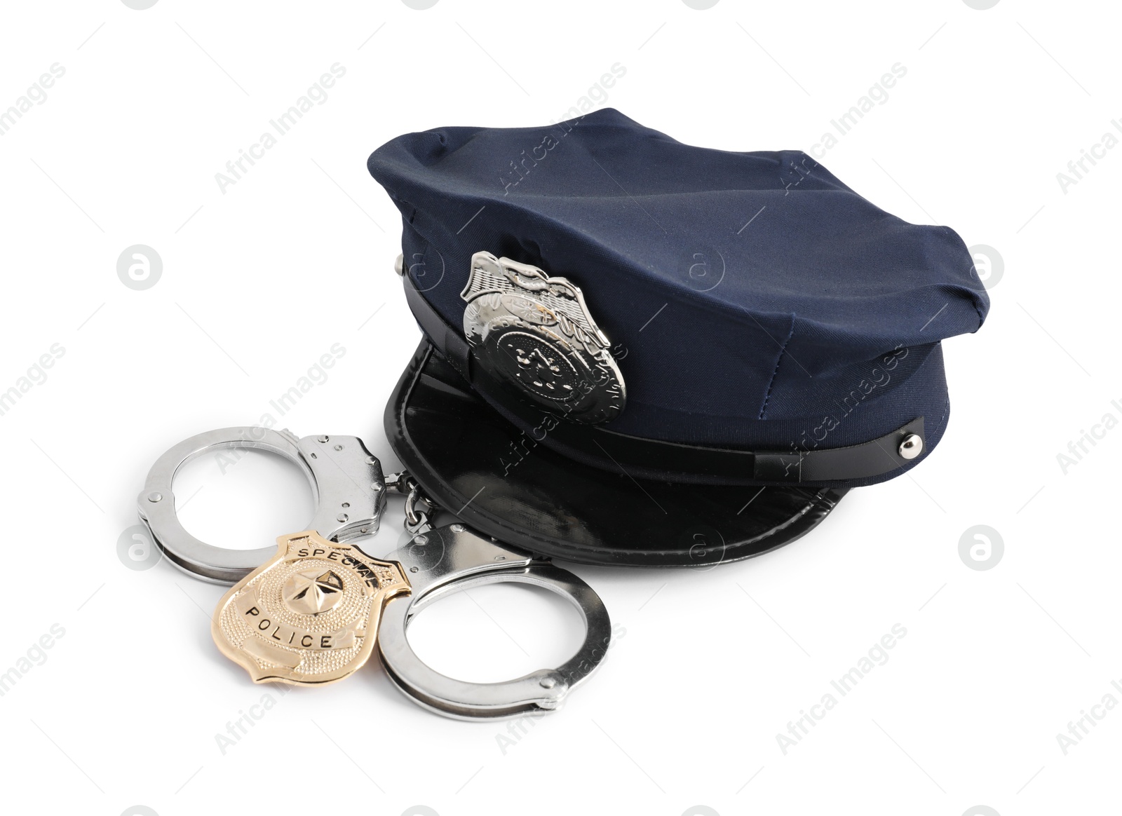 Police cap, badge and handcuffs on white background Photo of Police cap, badge and handcuffs on white background