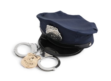 Photo of Police cap, badge and handcuffs on white background