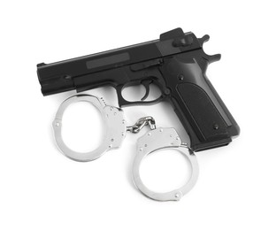 Photo of Gun and handcuffs on white background, top view. Police equipment