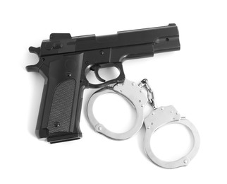 Photo of Gun and handcuffs on white background, top view. Police equipment