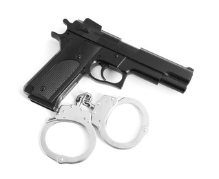 Photo of Gun and handcuffs on white background, top view. Police equipment