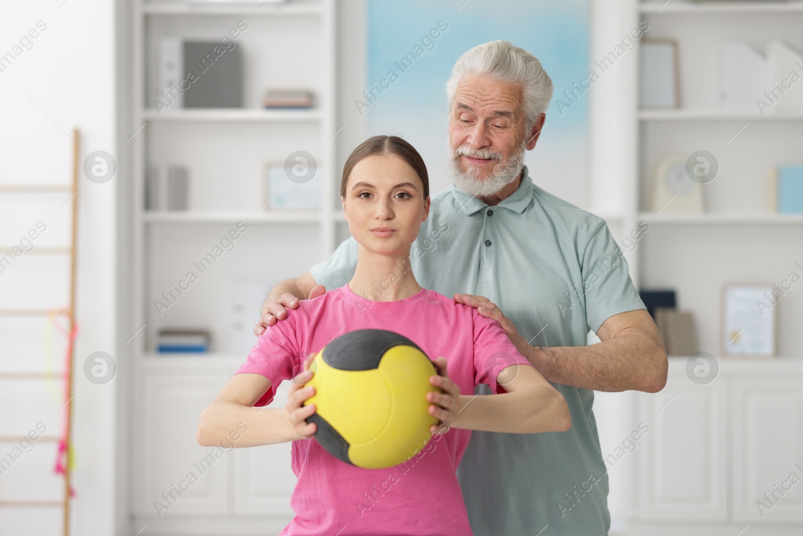 Doctor and patient exercising with medicine ball in clinic Photo of Doctor and patient exercising with medicine ball in clinic