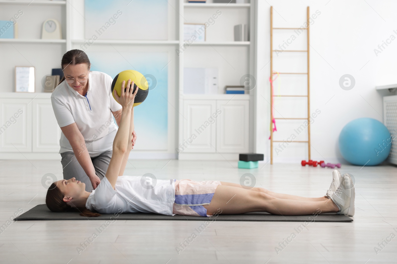 Doctor and patient exercising with medicine ball in clinic Photo of Doctor and patient exercising with medicine ball in clinic