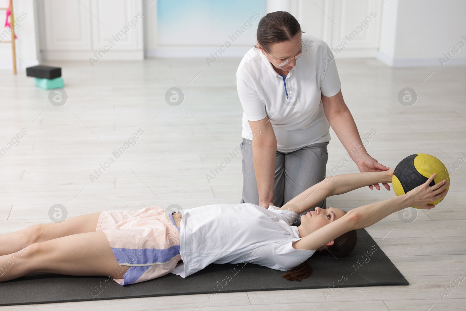 Doctor and patient exercising with medicine ball in clinic Photo of Doctor and patient exercising with medicine ball in clinic
