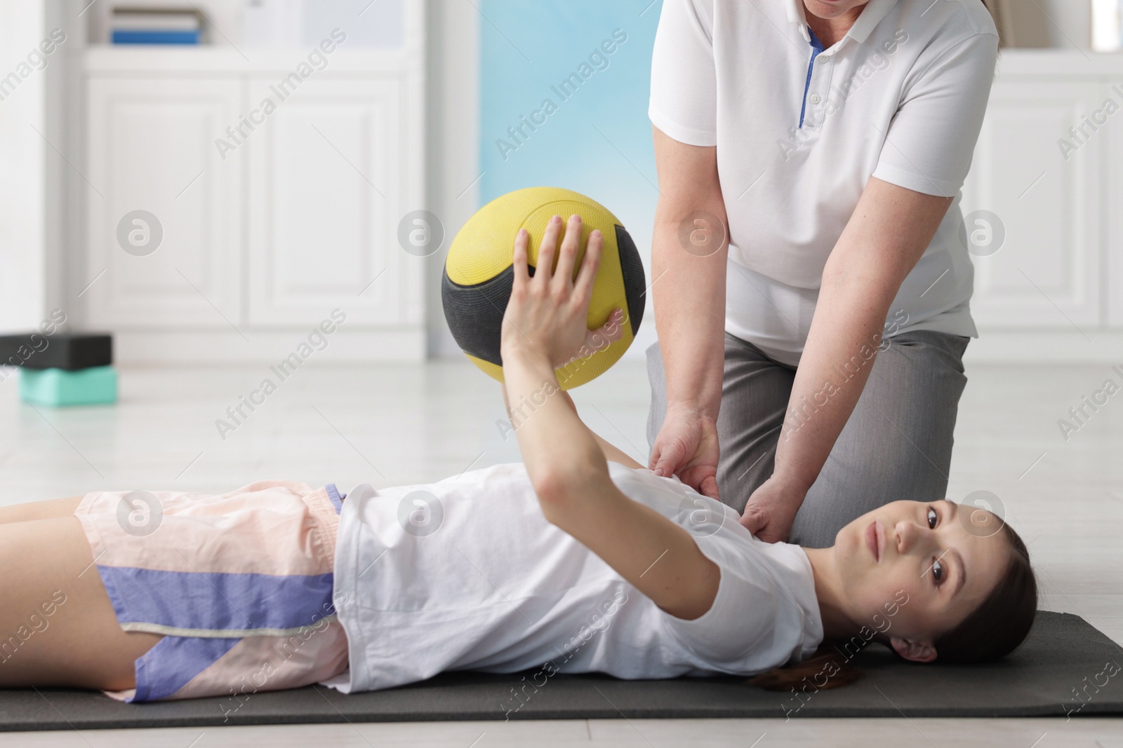 Doctor and patient exercising with medicine ball in clinic Photo of Doctor and patient exercising with medicine ball in clinic