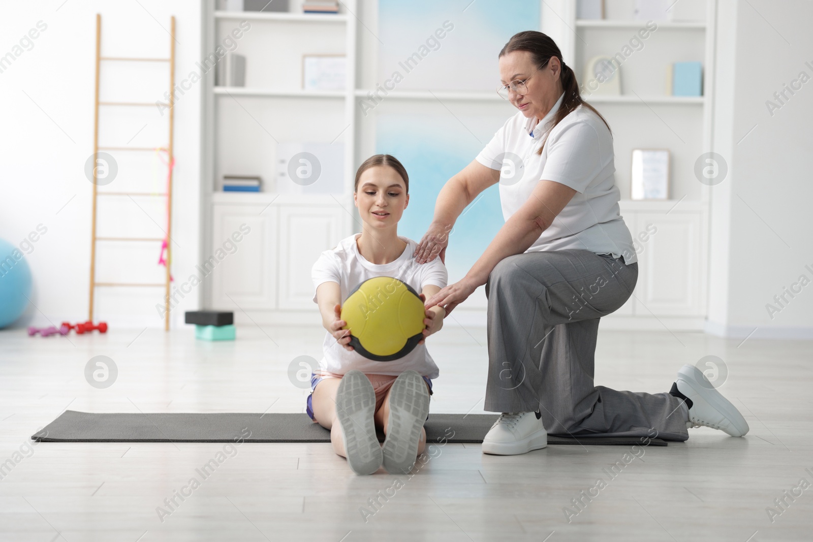 Doctor and patient exercising with medicine ball in clinic Photo of Doctor and patient exercising with medicine ball in clinic