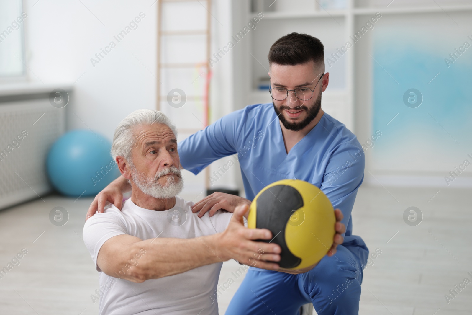 Doctor and patient exercising with medicine ball in clinic Photo of Doctor and patient exercising with medicine ball in clinic