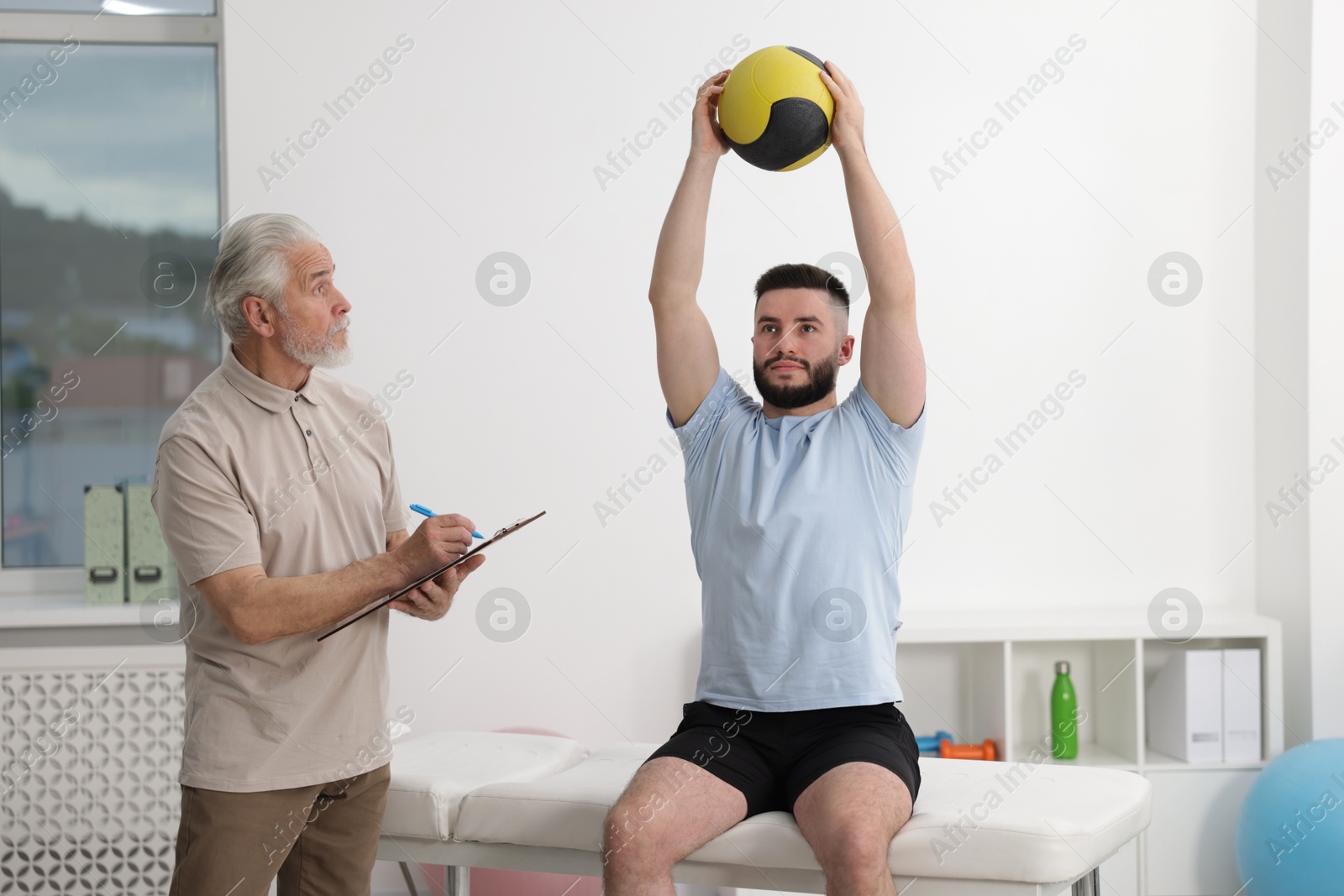 Doctor and patient exercising with medicine ball in clinic Photo of Doctor and patient exercising with medicine ball in clinic