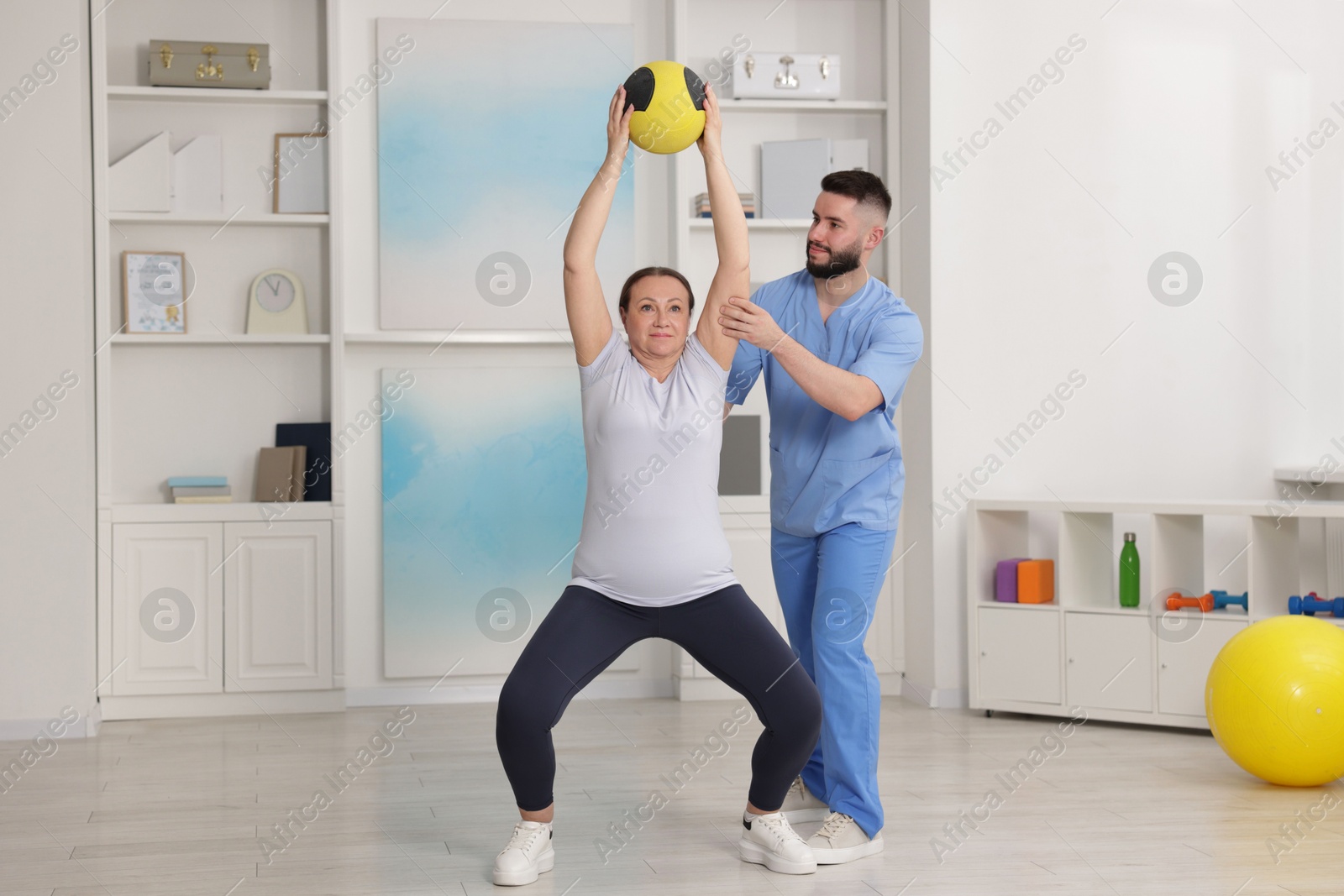 Doctor and patient exercising with medicine ball in clinic Photo of Doctor and patient exercising with medicine ball in clinic